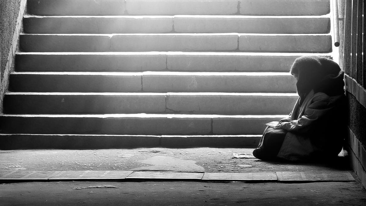 a woman sitting at the bottom of a stairwell