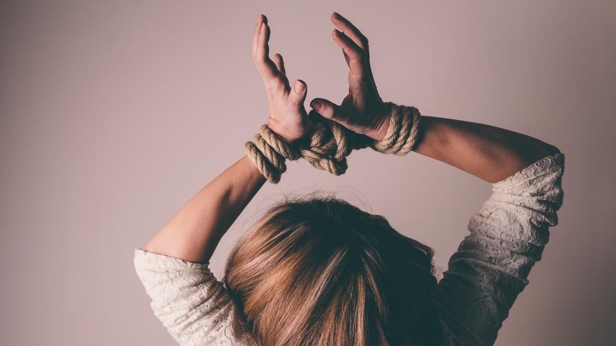 a woman holding her hands up, which are tied