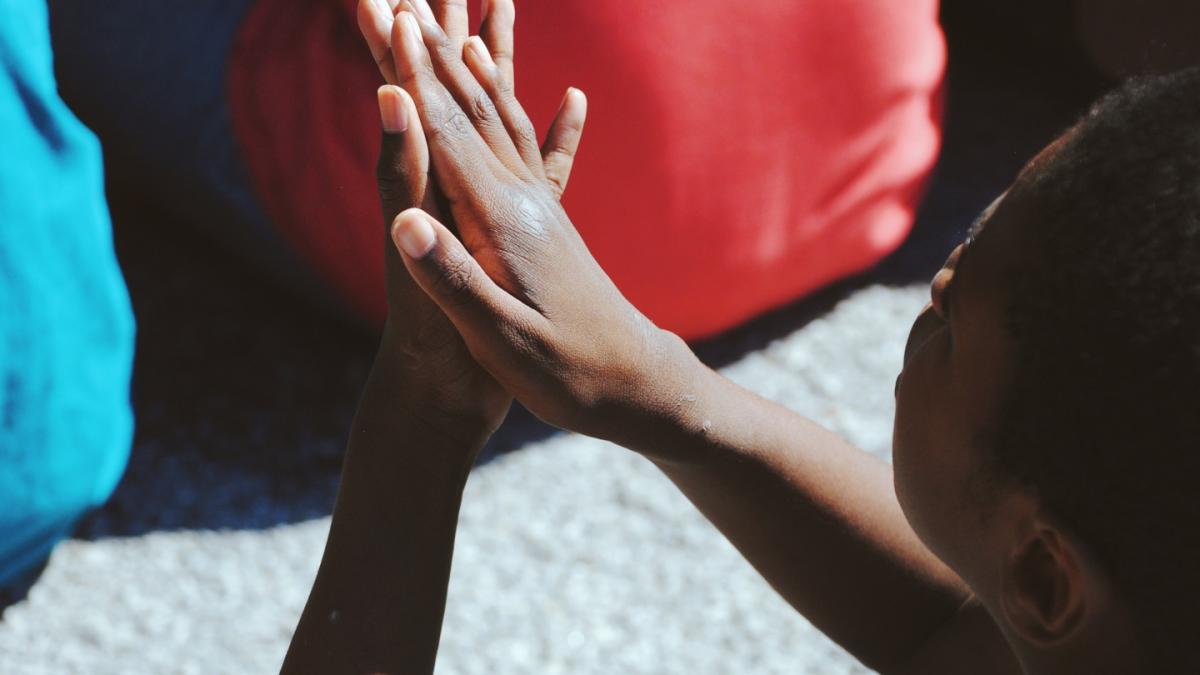 a child holding his hands together
